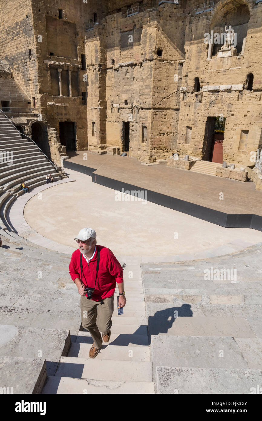 Di mezza età solo turista maschio con fotocamera ad esplorare i ruderi del Teatro Romano in arancione, Provenza, Francia Foto Stock