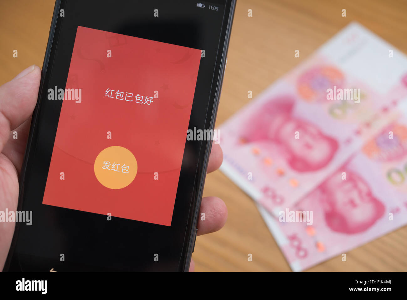 Zhongshan,China-Feb 21,2016:una tasca rosso sul cellulare è pronto per essere inviato su WeChat per il capodanno cinese con RMB sullo sfondo Foto Stock