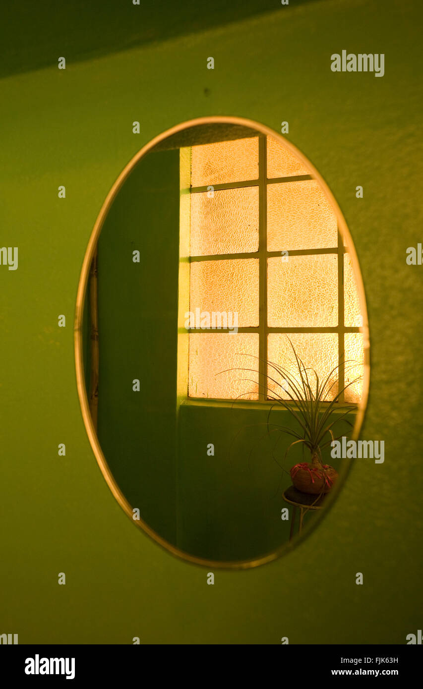 Abstract forme geometriche: la riflessione di un reticolo di forma  rettangolare di colore giallo semitrasparente di Windows in un specchio  ovale su una parete verde Foto stock - Alamy