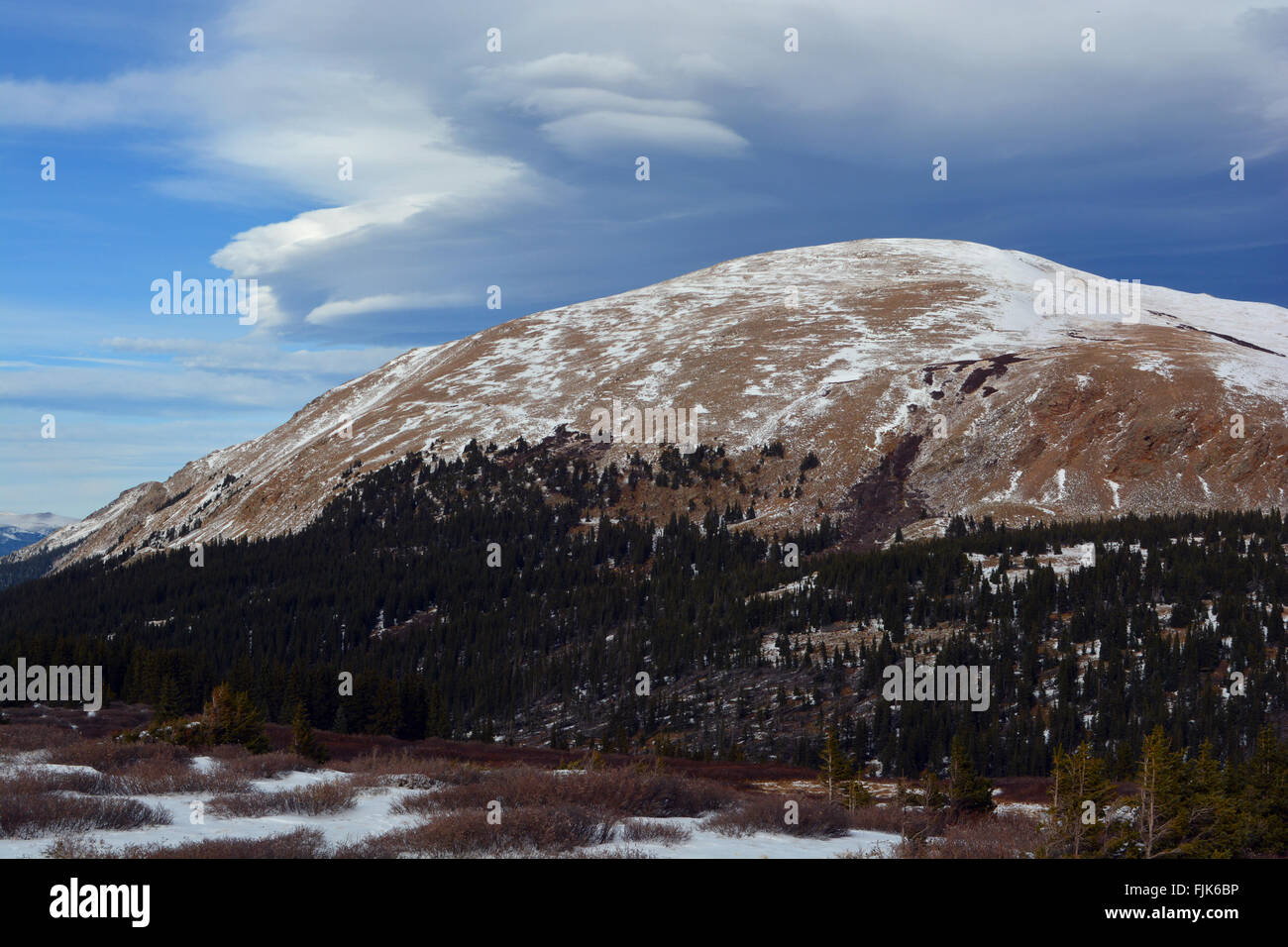 Strano lenticolare di nuvole sopra una coperta di neve Mountain Top Foto Stock