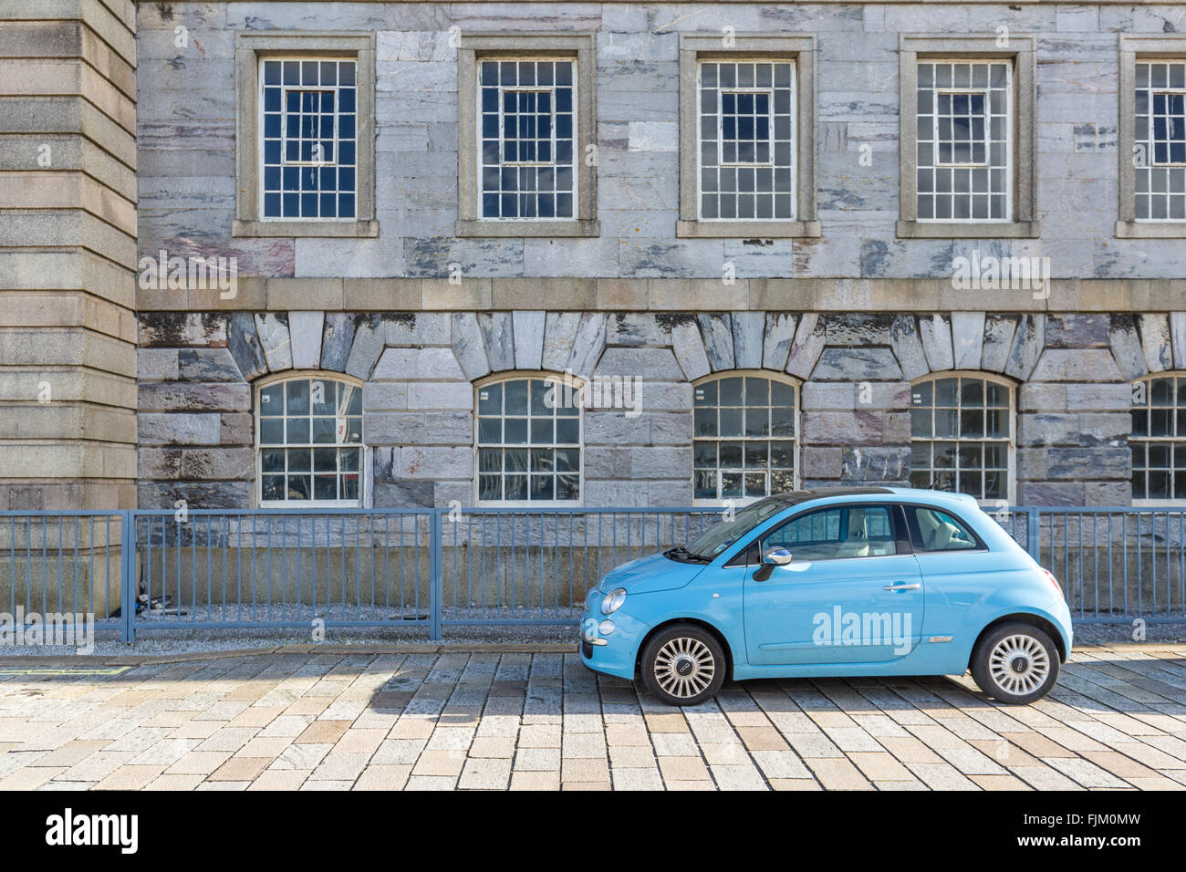 Un blu 500 Fiat auto parcheggiate davanti a un interessante edificio Foto Stock