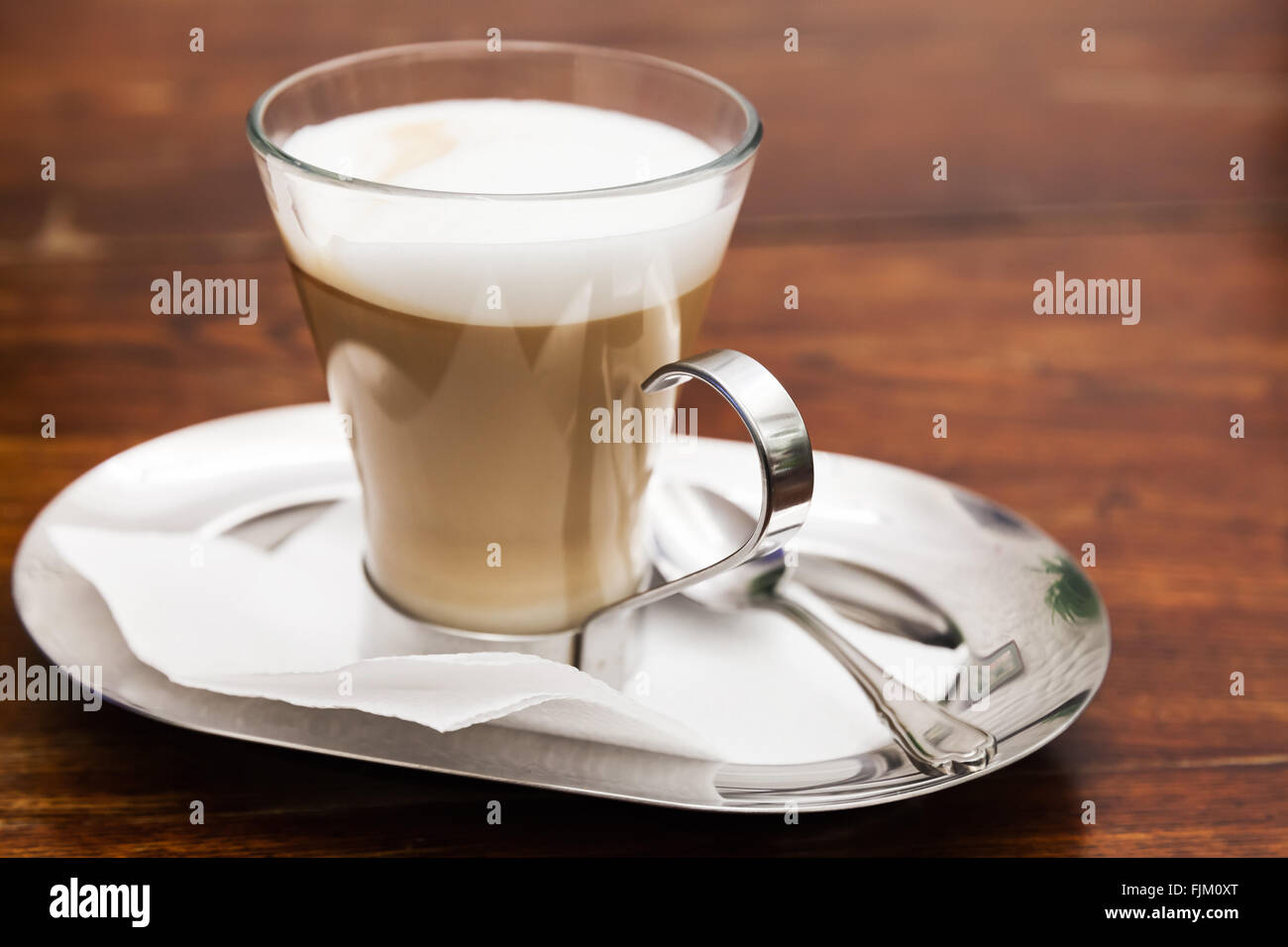 Il Cappuccino. Tazza di caffè con schiuma di latte si erge su un tavolo di legno nella caffetteria Foto Stock