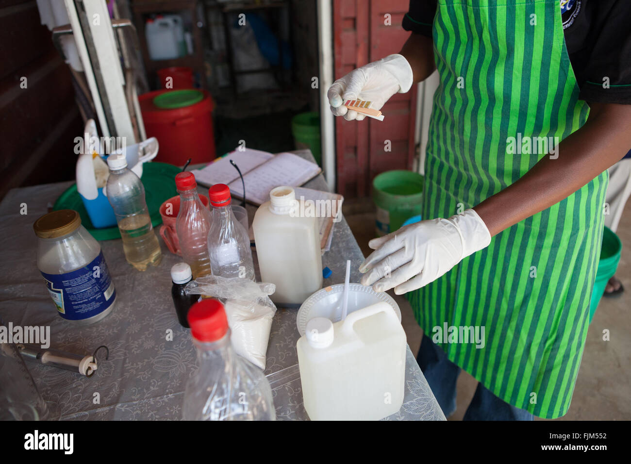 Un imprenditore femmina test del pH di equilibrio della sua casa fatta di sapone, Tanzania Foto Stock