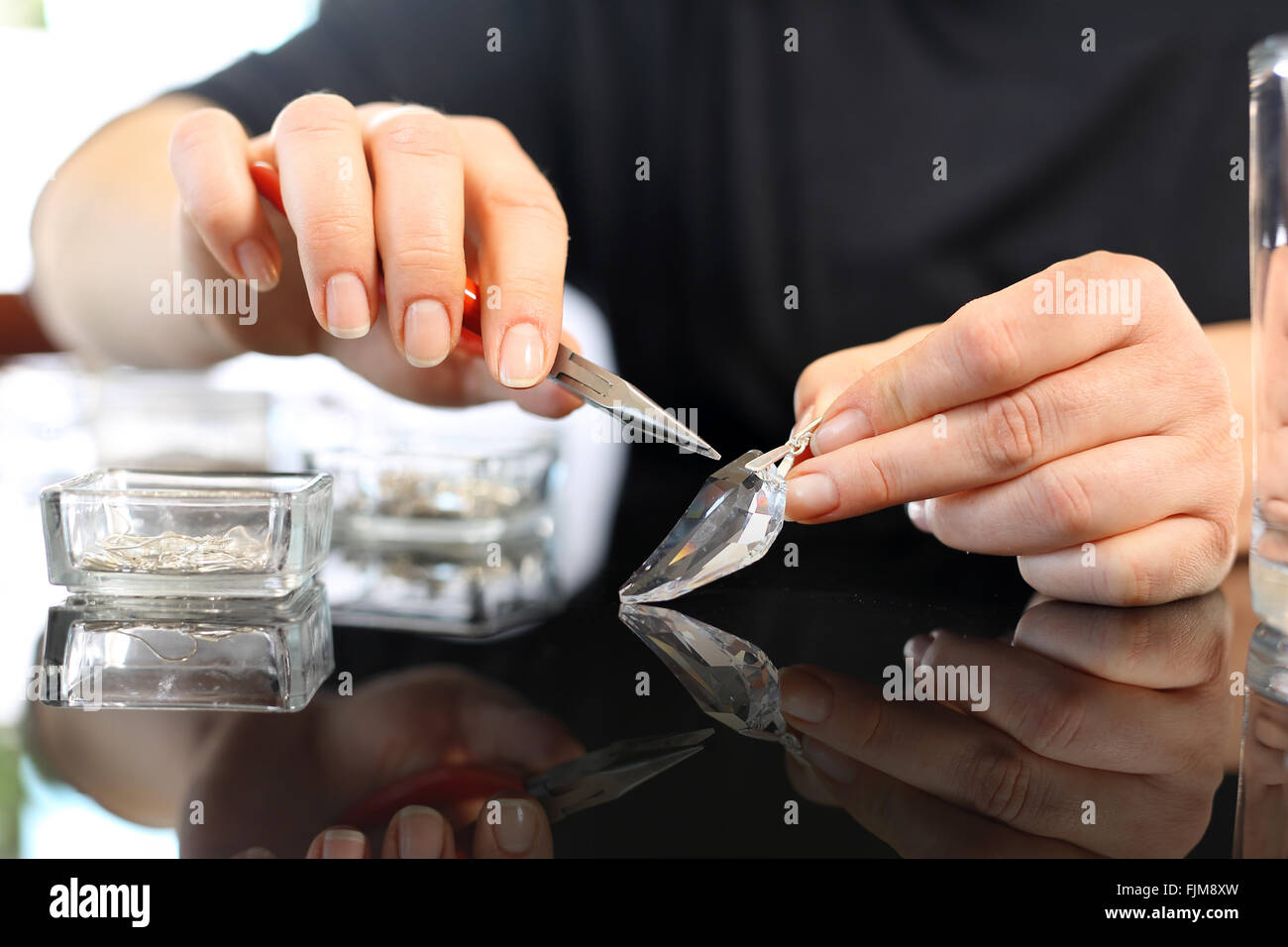 Workshop jewelery. Gioielli Swarovski crystal. Donna mani un gioielliere mentre si lavora su articoli di gioielleria Foto Stock
