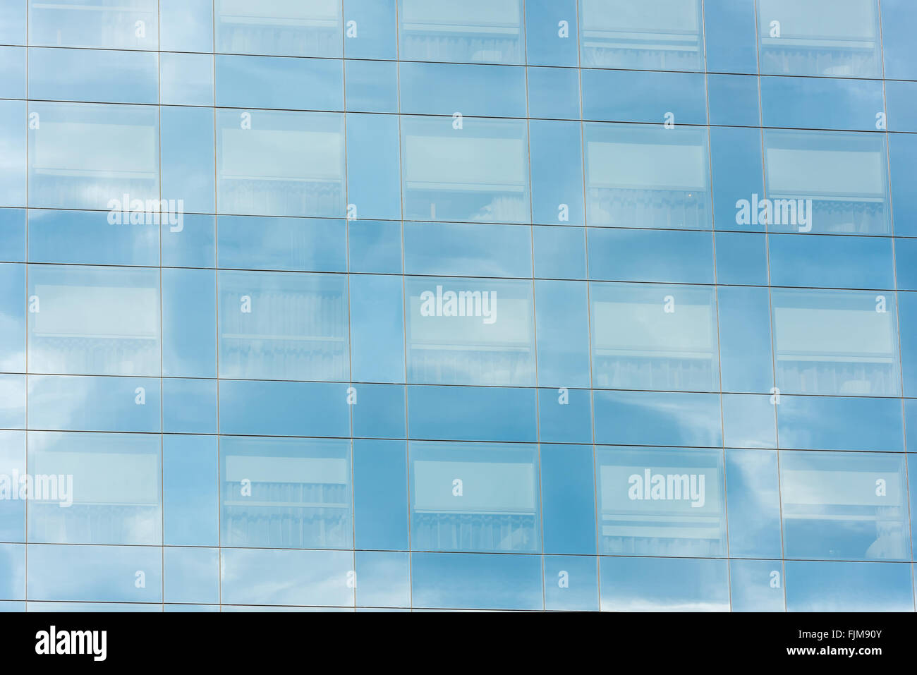 Cielo blu e nuvole riflettono in Windows del moderno edificio per uffici Foto Stock