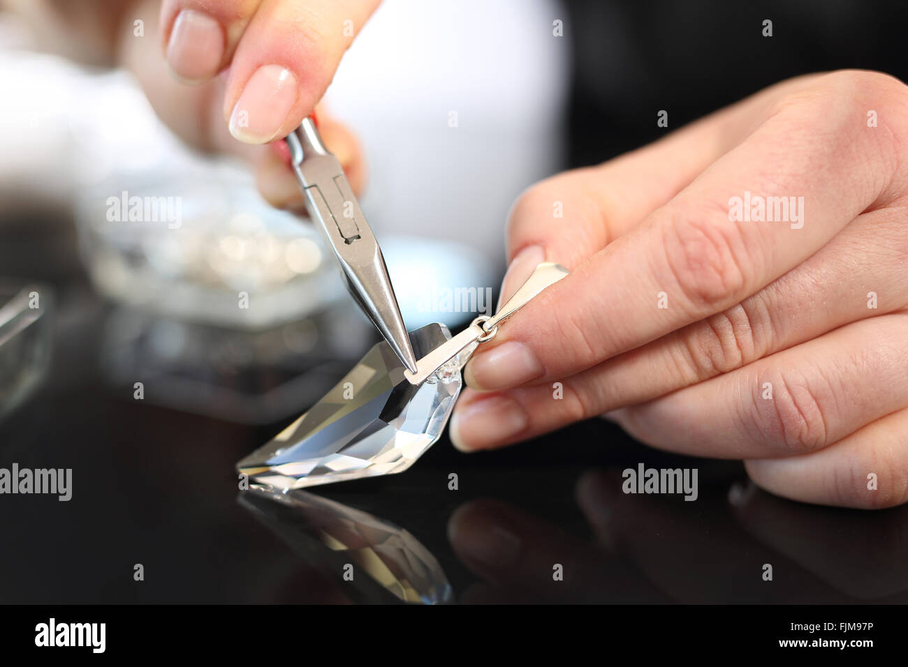 Workshop jewelery. Gioielli Swarovski crystal. Donna mani un gioielliere mentre si lavora su articoli di gioielleria Foto Stock