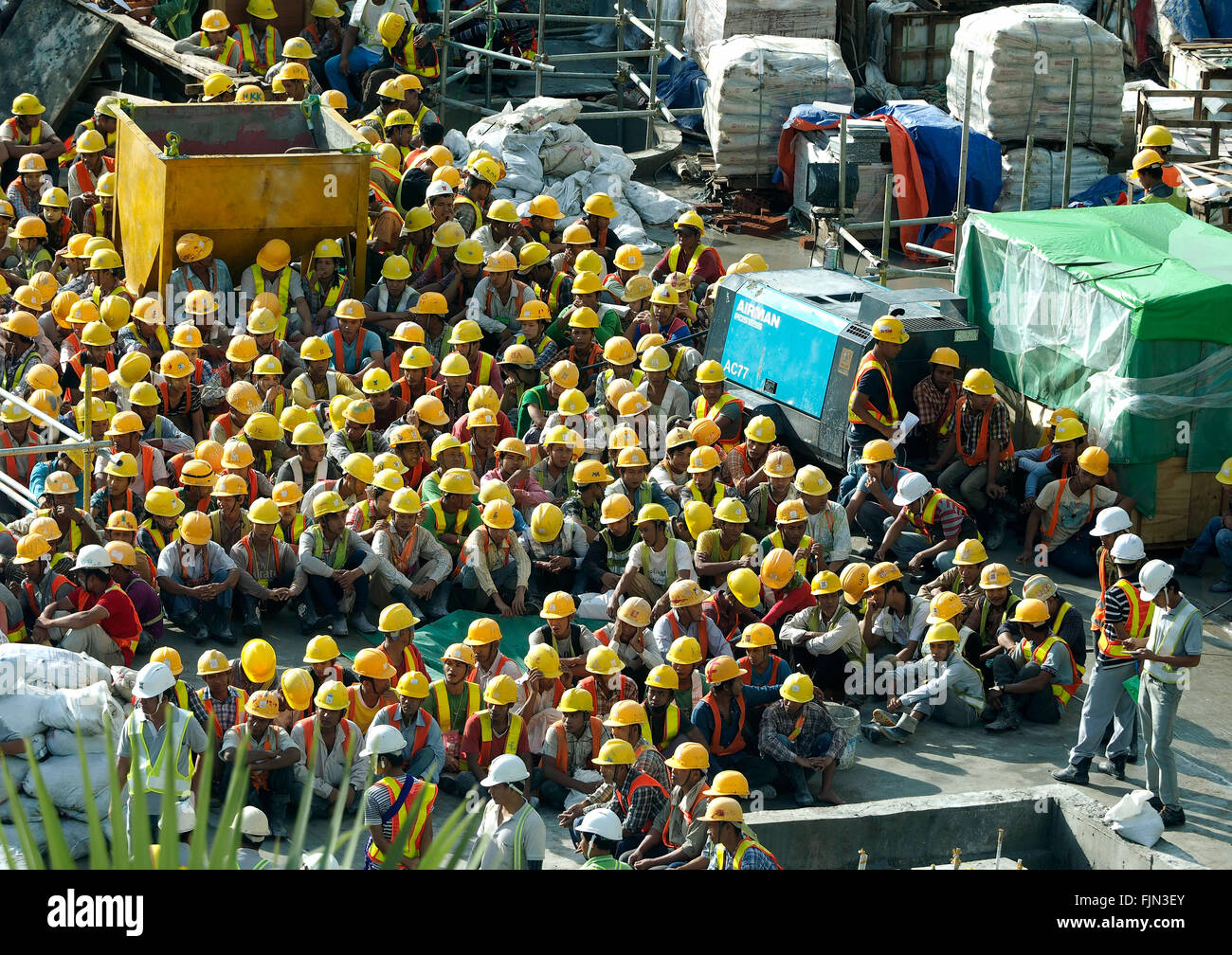Costruzione di lavoratori in attesa di mattina briefing Yangon, (ex Rangoon) Myanmar Foto Stock