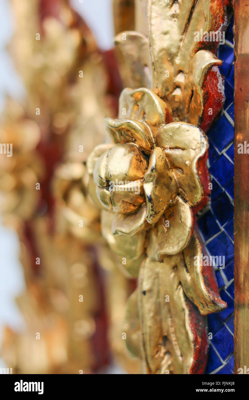 Closeup fiore d'oro sulla parete del tempio thailandese Foto Stock