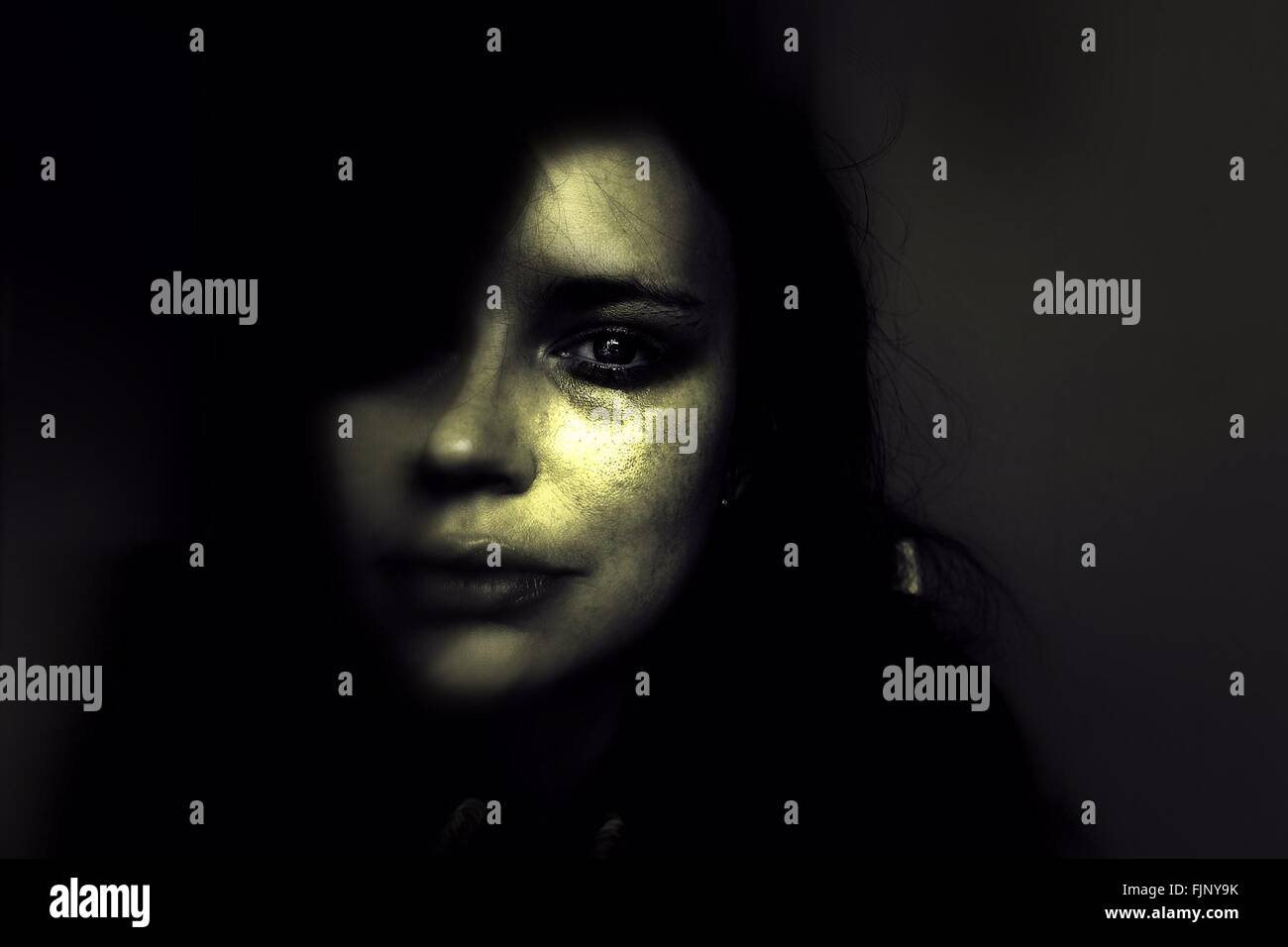 In primo piano il ritratto di donna triste in camera oscura Foto Stock