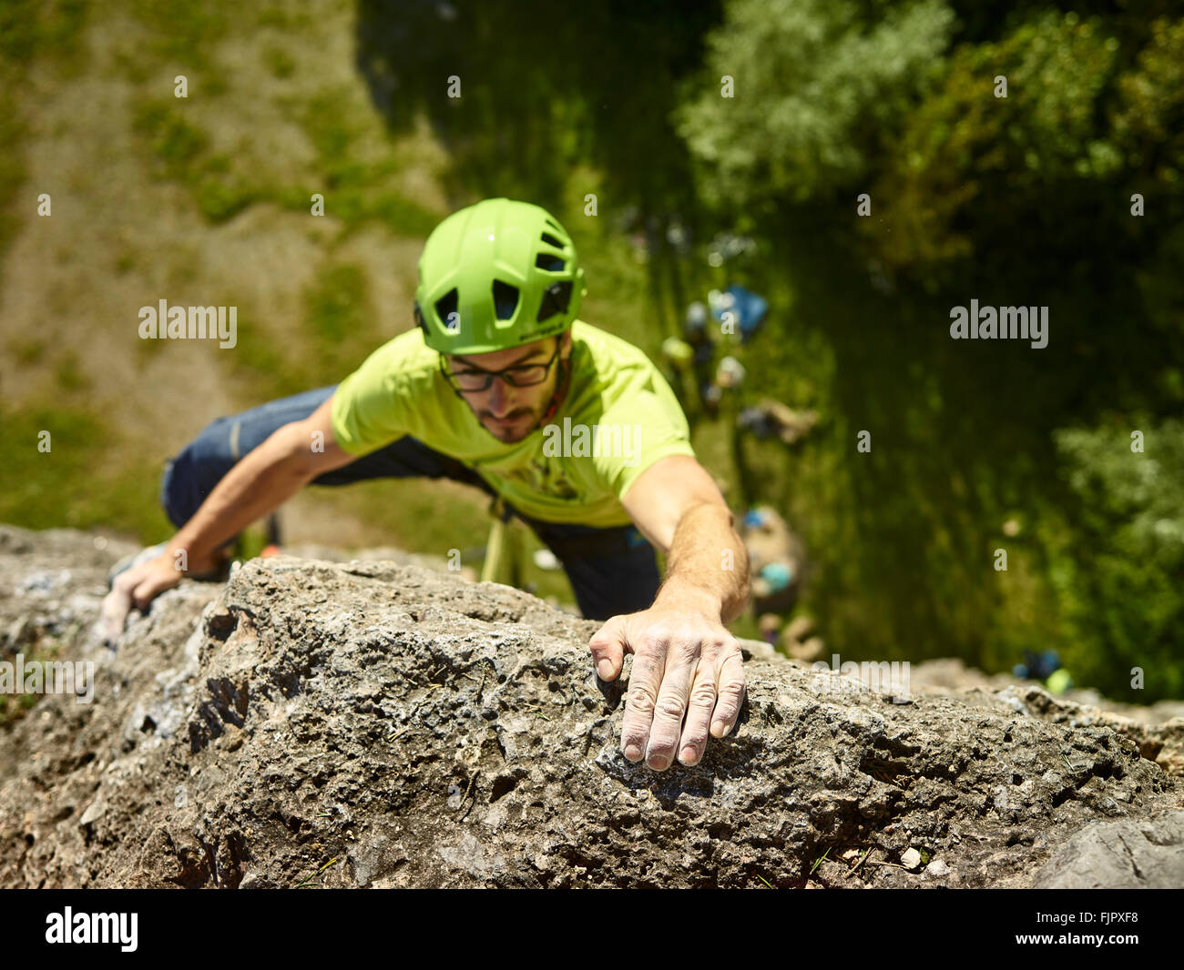 Scalatore con casco arrampicata su una rockface, Höttingersteinbruch, Innsbruck, in Tirolo, Austria Foto Stock
