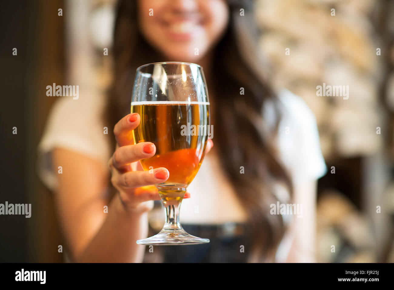 Donna felice tiene un bicchiere di progetto birra lager Foto Stock