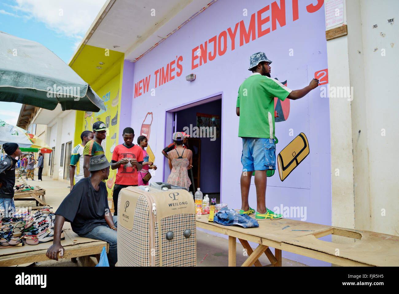 L'uomo decorare (pittura) un negozio facede al mercato Kamwalan, Lusaka. Foto Stock
