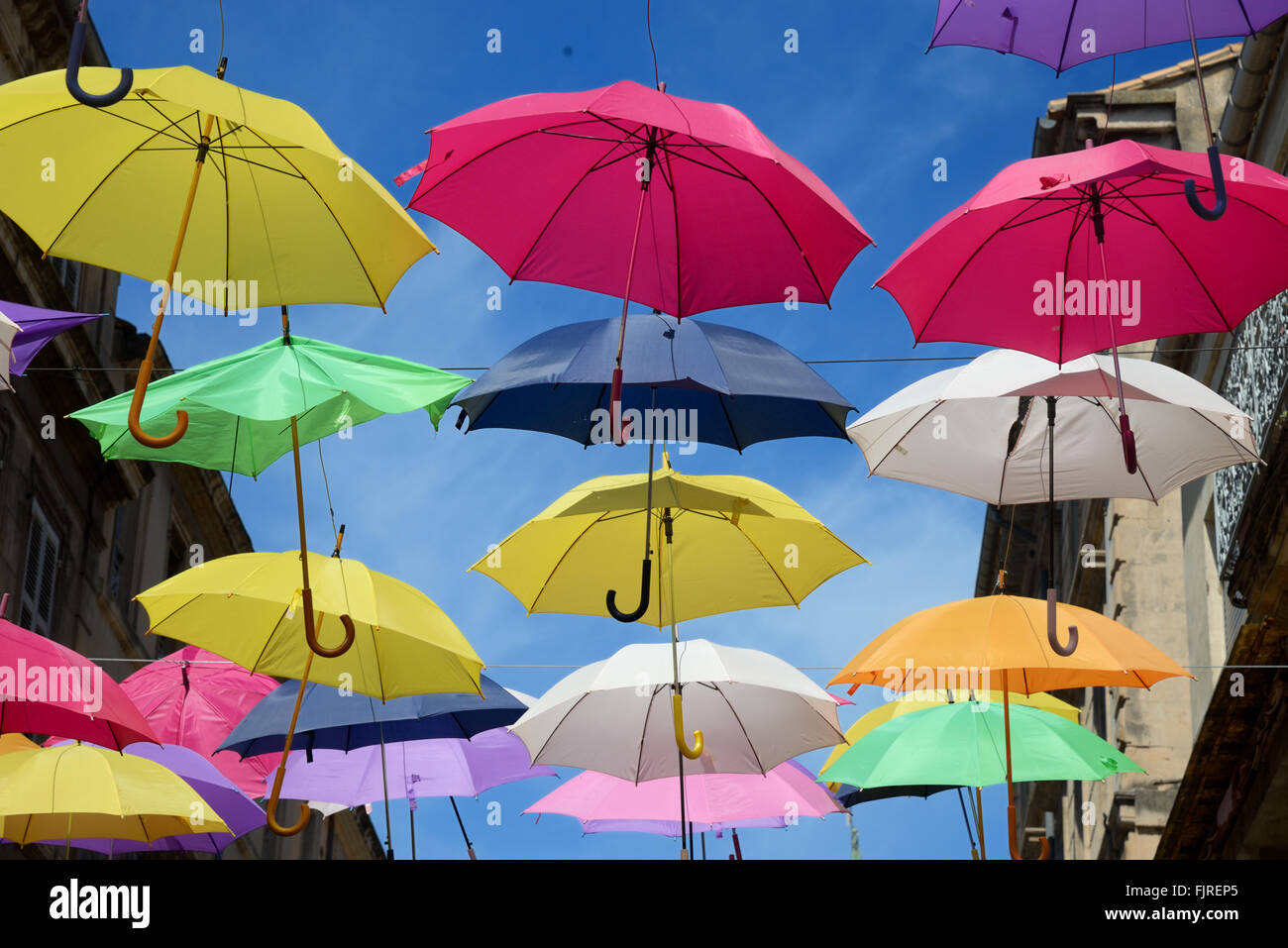 Visualizzazione di ombrelloni colorati stagliano contro il cielo blu. Arte di strada o di installazione Arte in strade di Arles, Provenza, Francia Foto Stock