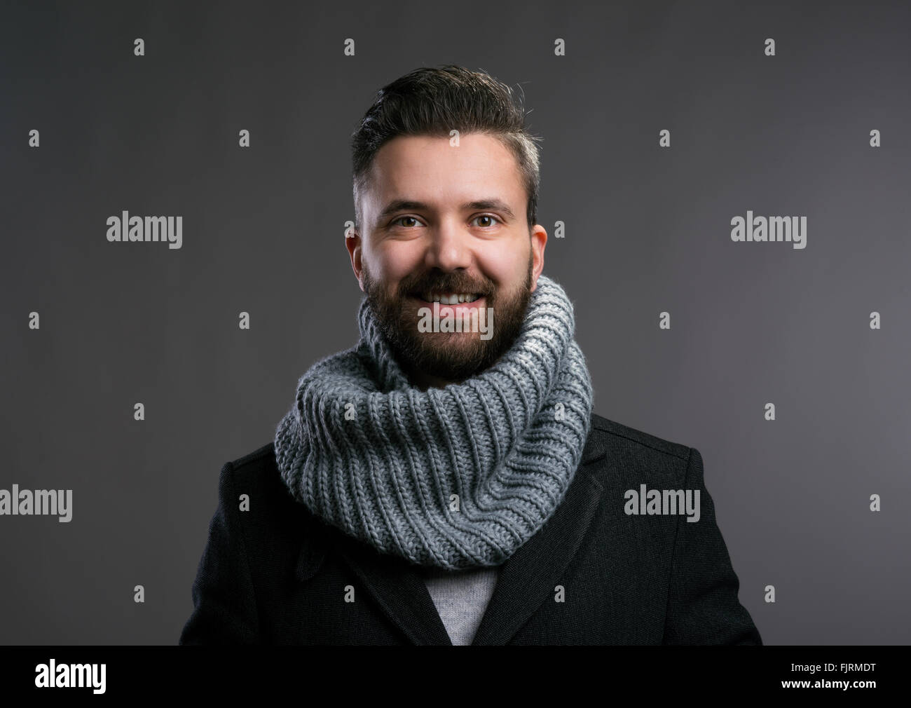 Uomo in cappotto e sciarpa kintted. Studio shot Foto Stock