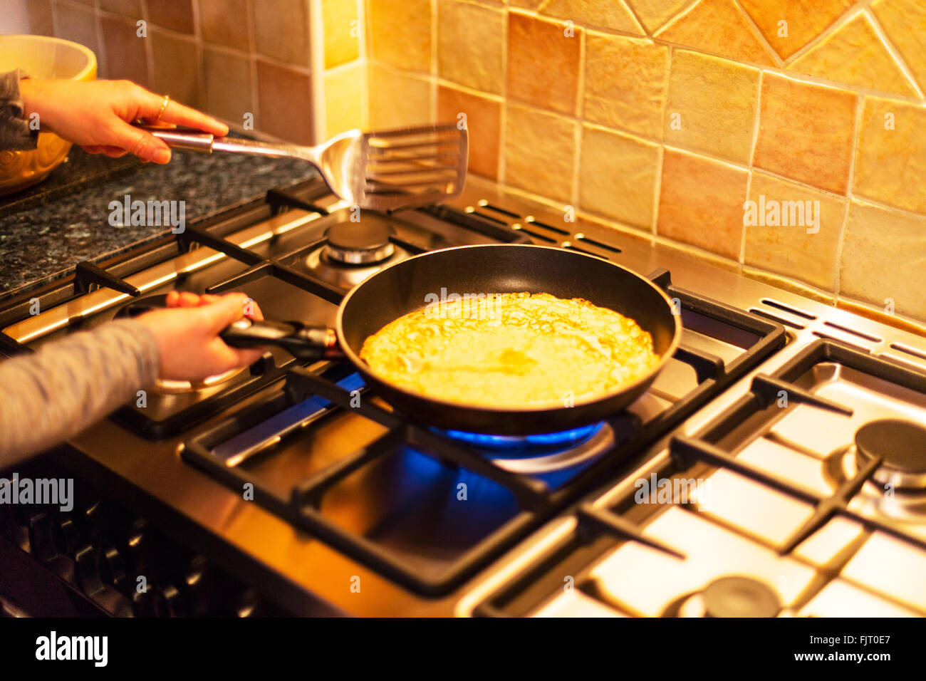 Fare frittelle pancake giorno cottura sui fornelli a gas padella cuocere donna Foto Stock