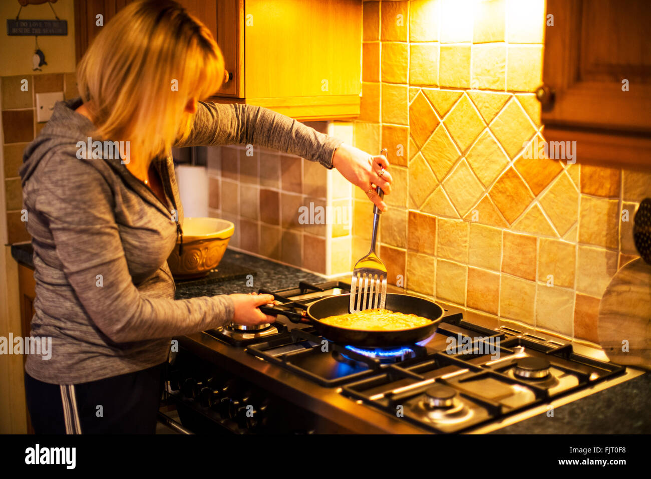 Fare frittelle pancake giorno cottura sui fornelli a gas padella cuocere donna Foto Stock