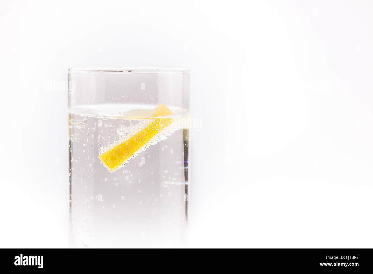Acqua di soda con una fettina di limone in flottante Foto Stock
