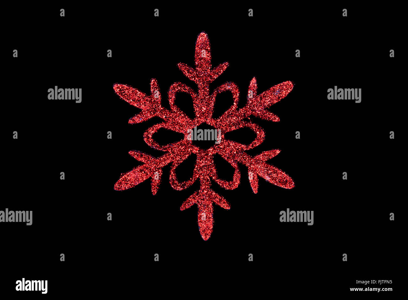 Rosso ornamento fiocco di neve su sfondo nero Foto Stock