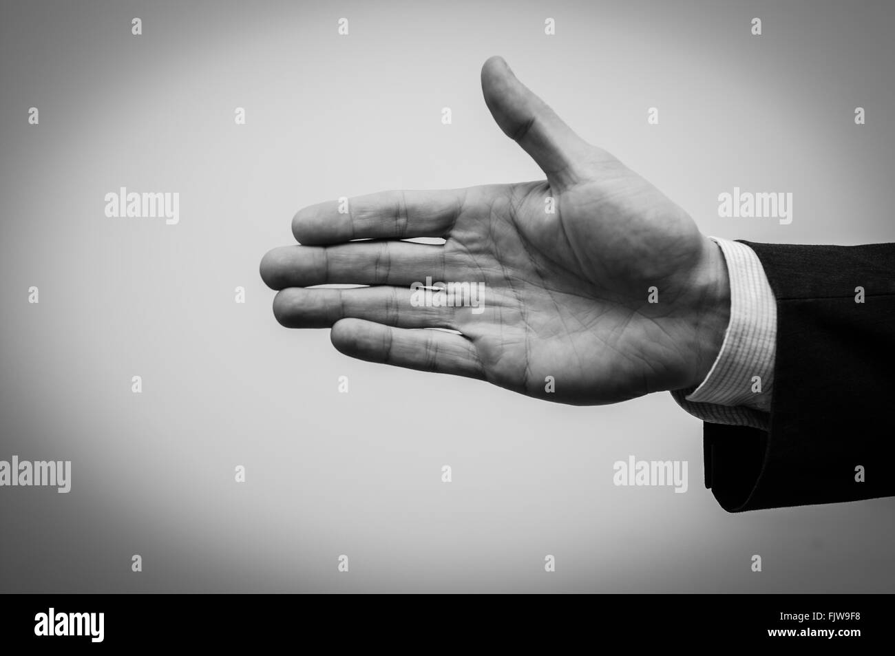 Caucasico maschio bianco che si estende la sua mano destra in bianco e nero Foto Stock