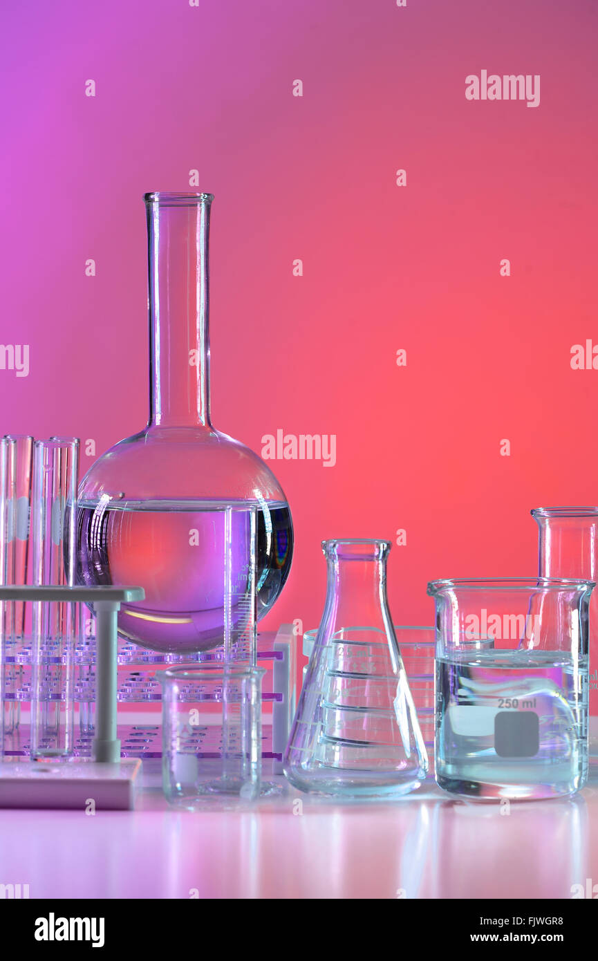Vetreria di laboratorio su sfondo colorato Foto Stock