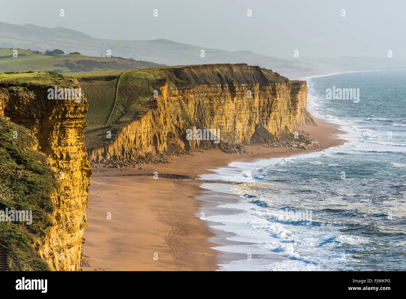 East Cliff West Bay e Burton Cliff Burton Bradstock nel Dorset glow sotto il sole invernale in gennaio. Credito Foto: Graham Hunt/Alamy Foto Stock