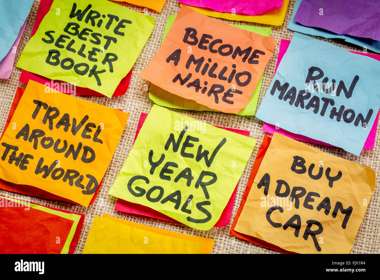 Diventare un milionario e irrealistico nuovo anno obiettivi o risoluzioni - colorata sticky notes su tela Foto Stock