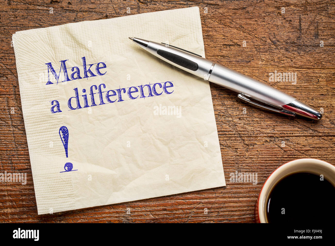 Fare la differenza! Un testo motivazionale su un tovagliolo con una tazza di caffè Foto Stock