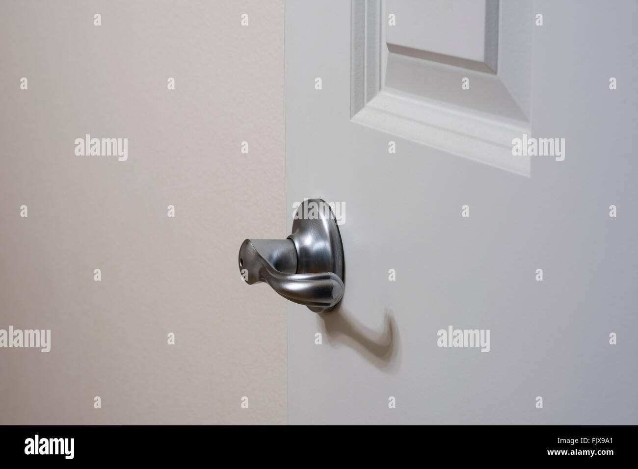 In color argento di stile leva maniglia della porta sulla porta interna. Foto Stock