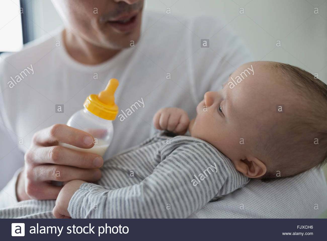 Padre alimentare baby boy con bottiglia Foto Stock
