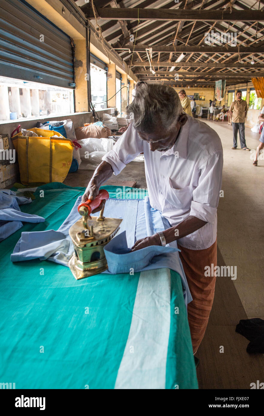 Un uomo che lavora in Kochi Dhobi Wallah Kerala India Foto Stock