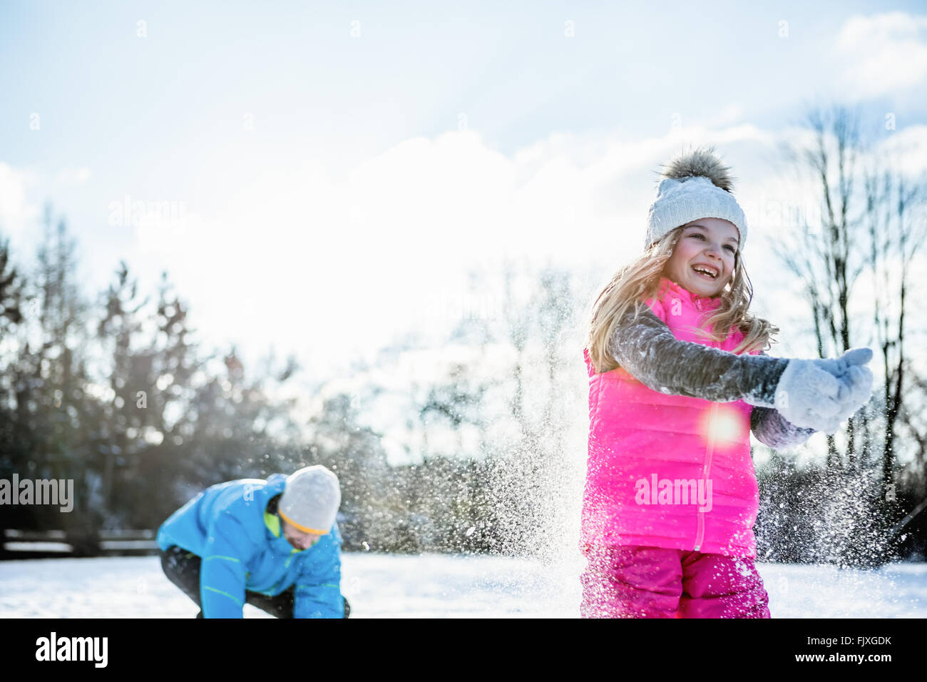 Padre e figlia la riproduzione di lotta con le palle di neve Foto Stock