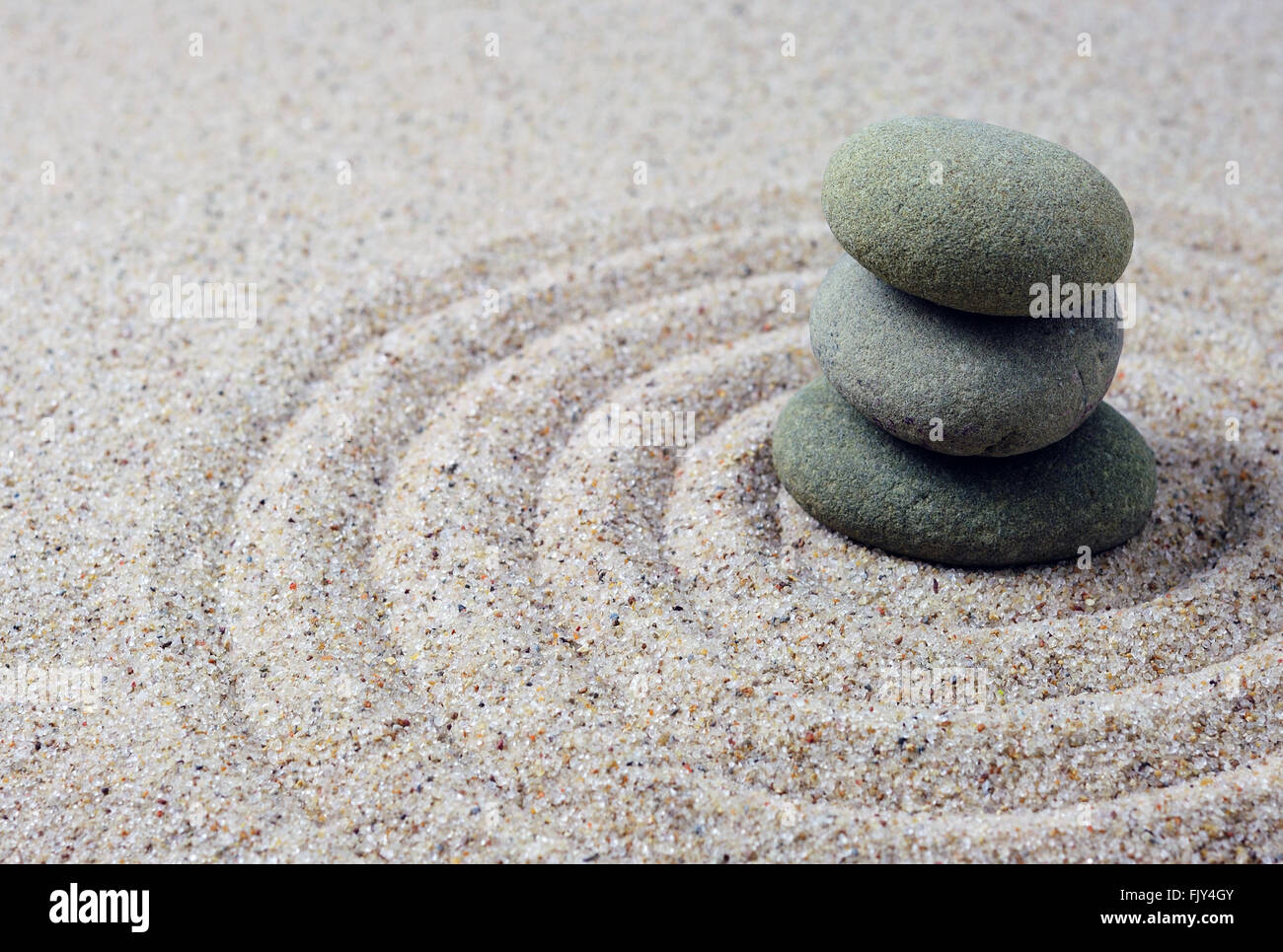 Pietre Zen su un rastrellamento di sabbia per la meditazione spa, massaggio, il concetto di benessere, equilibrio e armonia, la spiritualità e il concetto di rilassamento Foto Stock