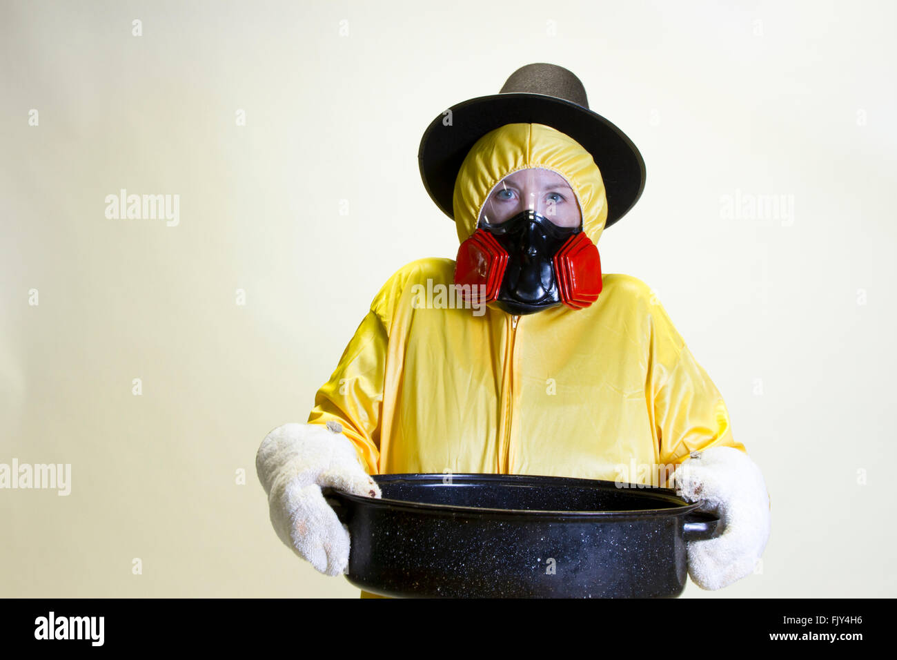 Donna matura in giallo hazmat suit e pellegrino hat holding teglia. Foto Stock