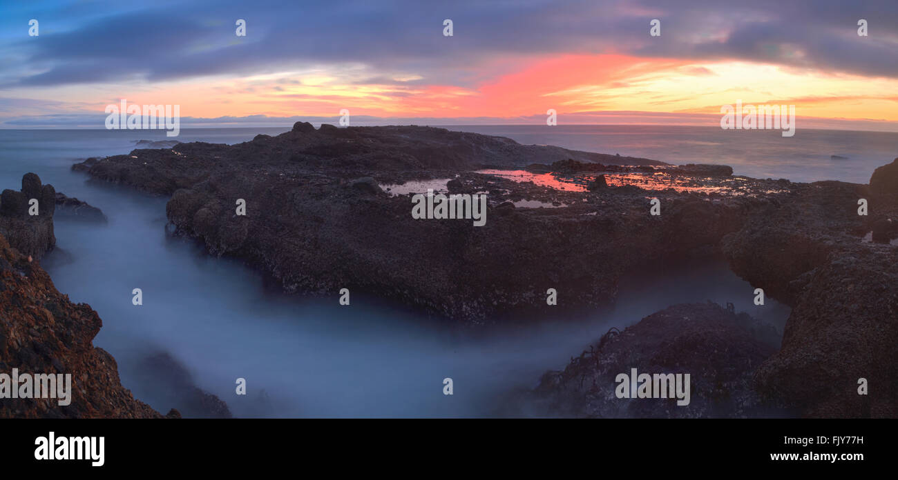 Una lunga esposizione del tramonto su rocce, dando una nebbia simile effetto sull'oceano in Laguna Beach, California, Stati Uniti Foto Stock
