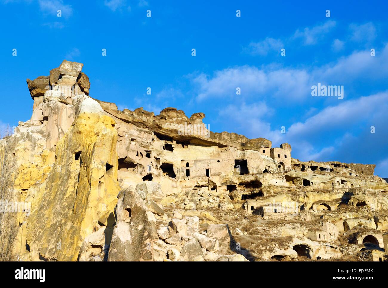Parte della scogliera abitazione complesso di antiche chiese cristiane e case nel villaggio di Cavusin vicino a Goreme, Cappadocia, Turchia Foto Stock