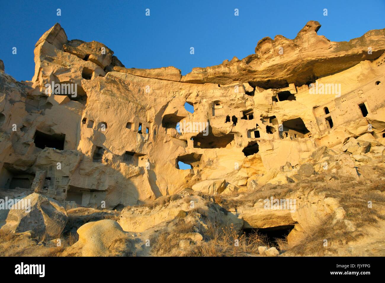 Parte della scogliera abitazione complesso di antiche chiese cristiane e case nel villaggio di Cavusin vicino a Goreme, Cappadocia, Turchia Foto Stock