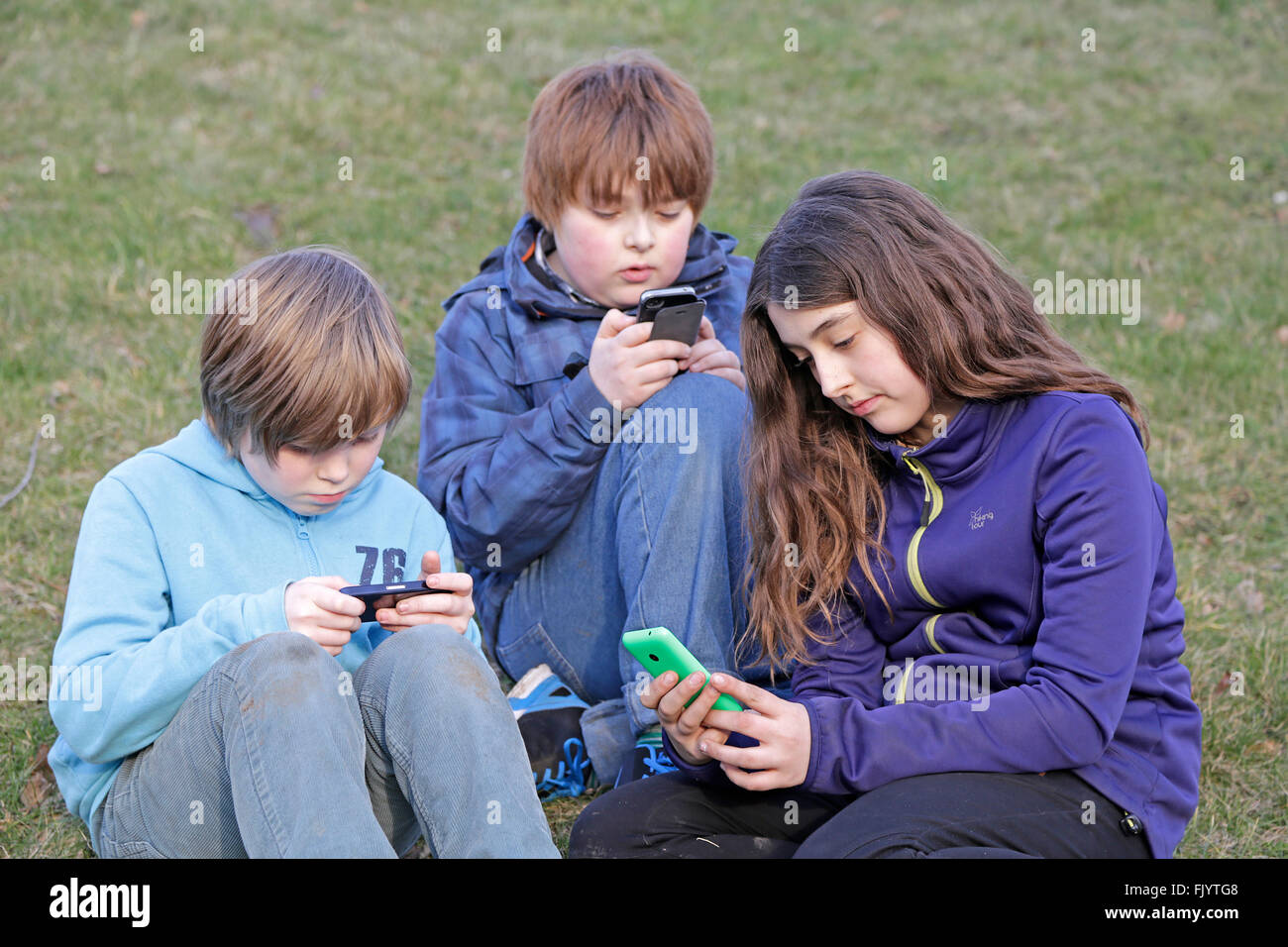 Bambini che giocano con il loro smartphone Foto Stock