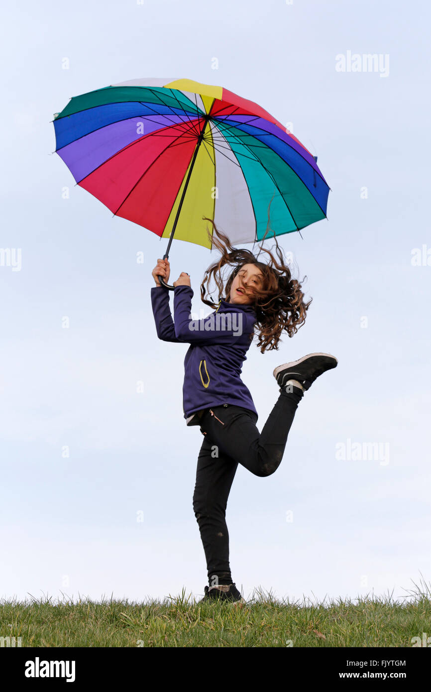 Ragazza in posa con ombrello coloratissimo Foto Stock