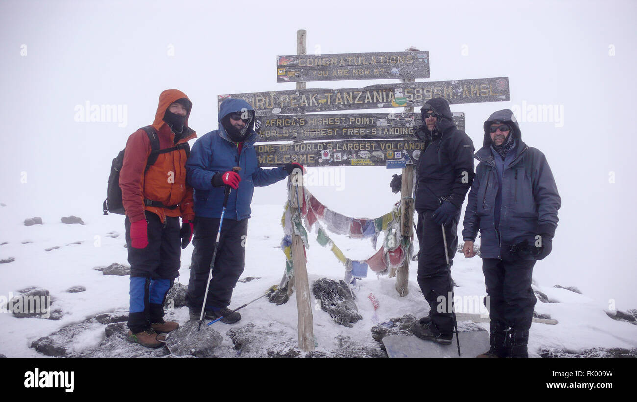 Quattro uomini, tre fratelli e un amico a Uhuru Peak, Monte Kilimanjaro. Foto Stock