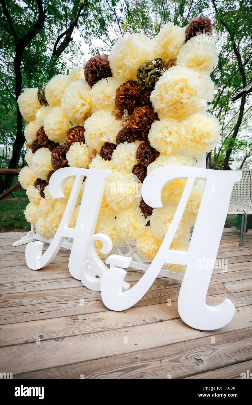 Fiore sfondo pompon a parete, decorazioni per matrimoni zona con lettere doppie a. Giallo e bianco di colore marrone. Foto Stock