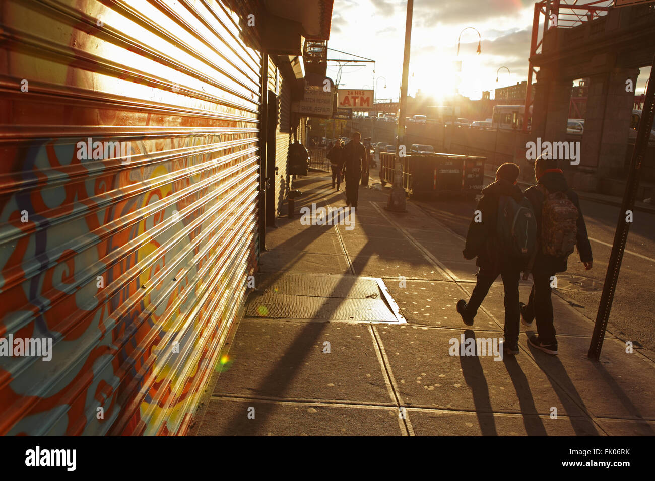 Due studenti a scuola a piedi a est nella Rising Sun giù Delancey Street sulla Lower East Side di Manhattan Foto Stock
