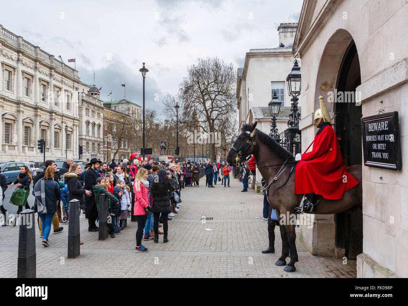 I turisti che guarda alla vita di protezione sul dovere al di fuori la sfilata delle Guardie a Cavallo su Whitehall, Westminster, London, England, Regno Unito Foto Stock