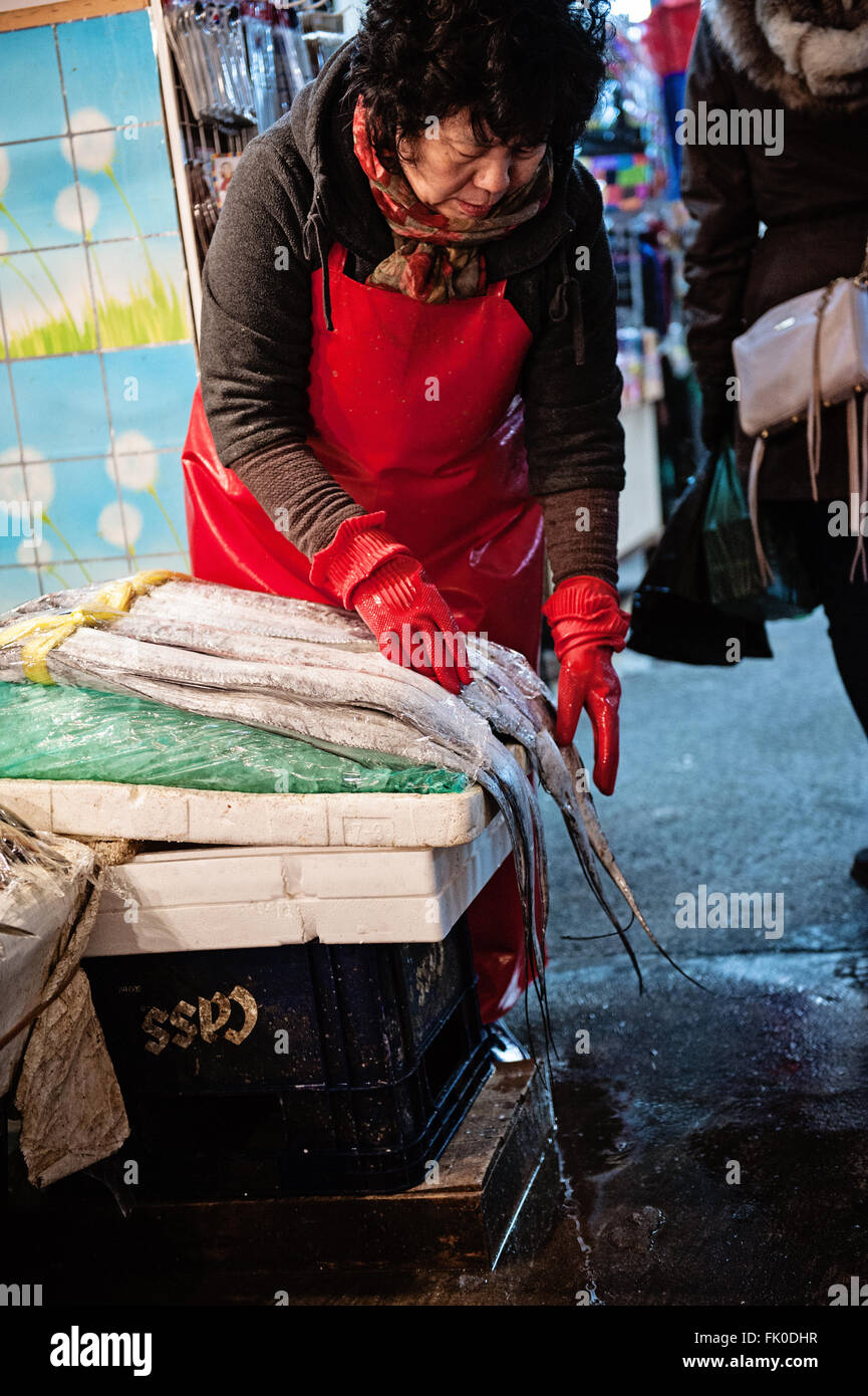 Un venditore di pesce al mercato Gwangjang a Seul, in Corea, prepara il loro prodotto Foto Stock