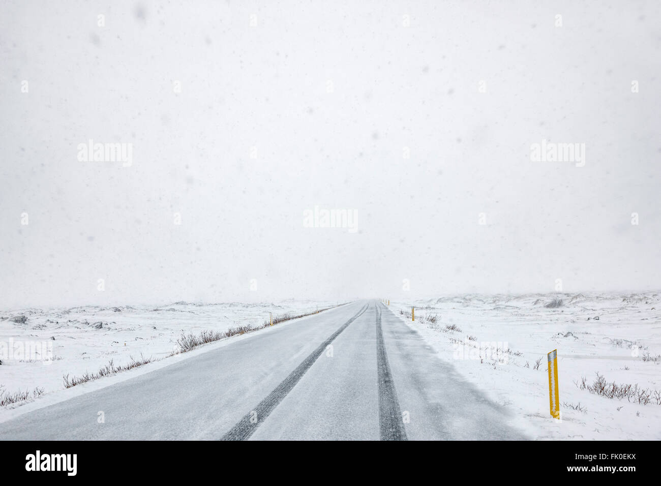 La caduta della neve sulla strada di un paese in Islanda in inverno Foto Stock