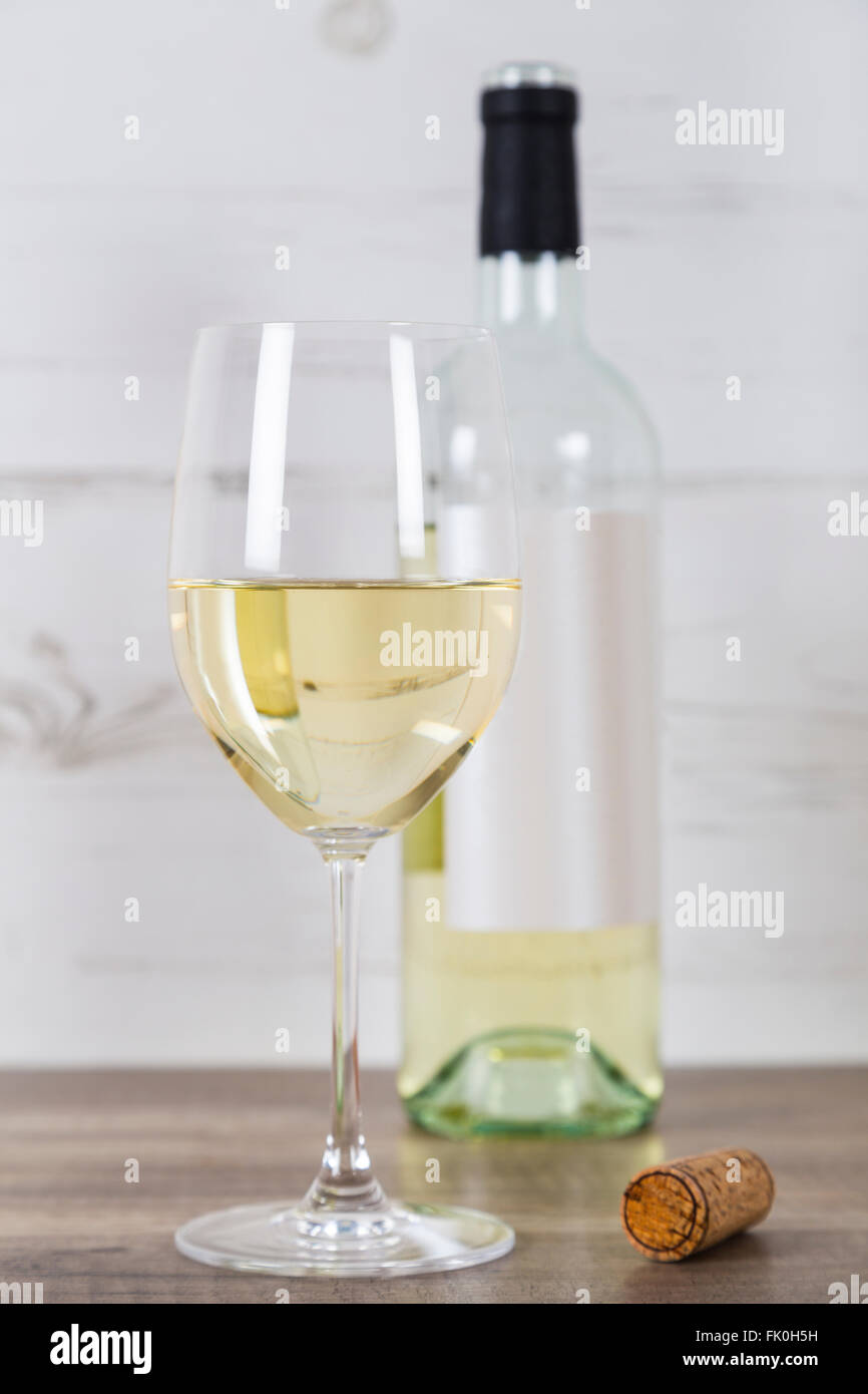Bicchiere di vino bianco e una bottiglia Foto Stock