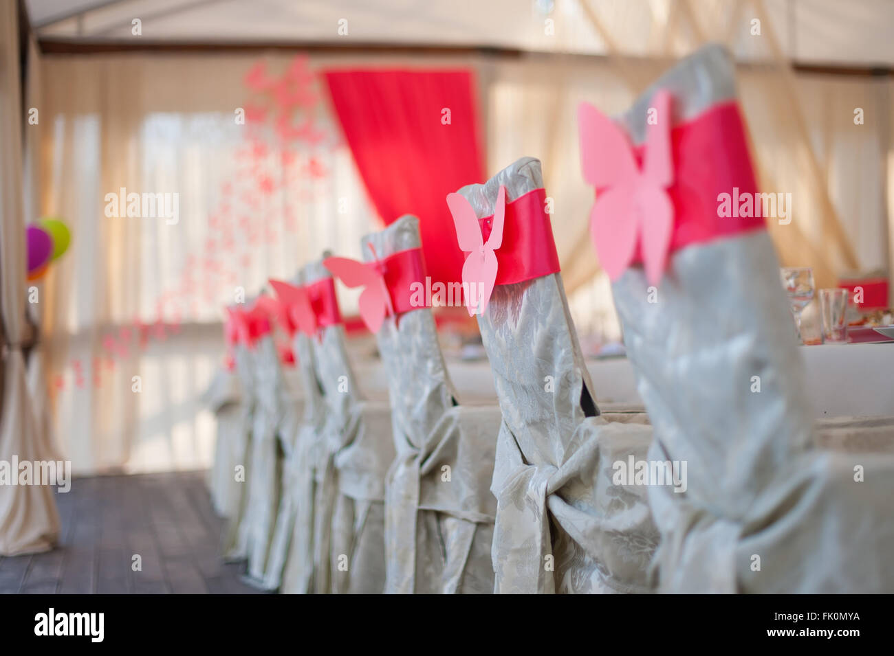 Sedie in bianco copre con un nastro rosso Foto Stock