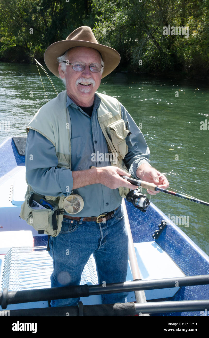 Ritratto di un felice pensionato uomo senior di trascorrere del tempo sulla pesca in acqua. Foto Stock