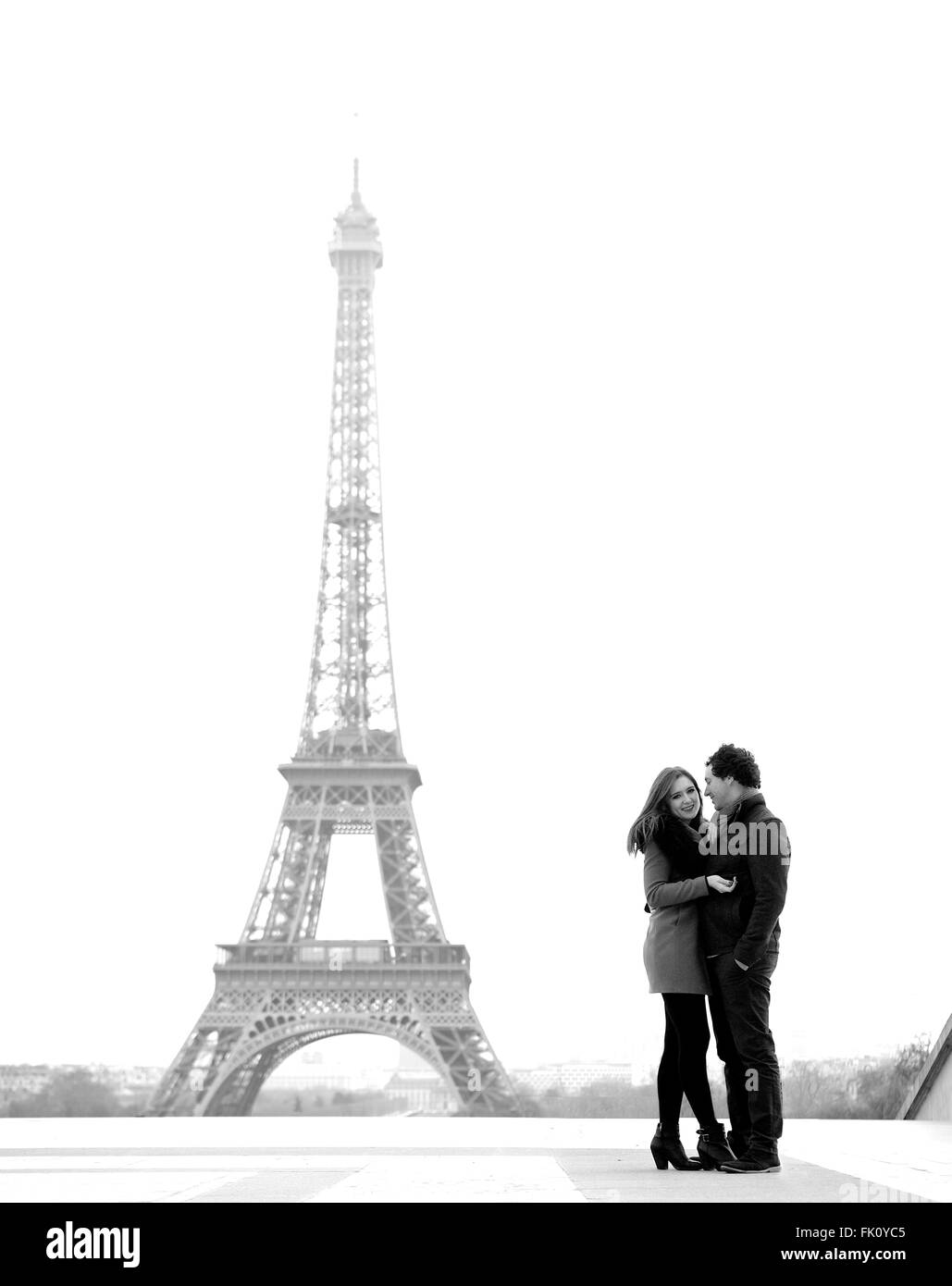 Giovane e in amore bruna giovane di fronte alla torre Eiffel, Parigi, al Trocadero che domina la città durante il giorno Foto Stock