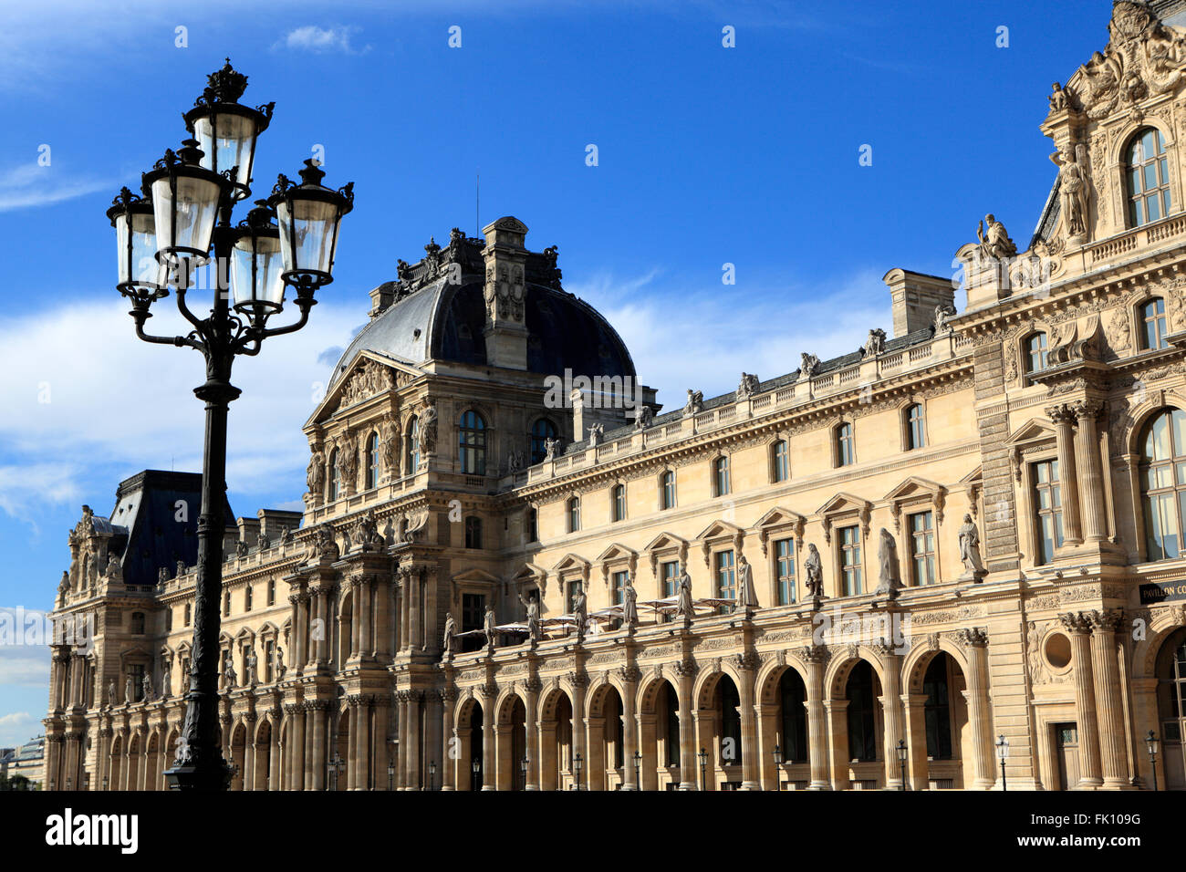 Architettura Rinascimentale e lampade di via al museo del Louvre a Parigi inondata dalla calda nel tardo pomeriggio la luce. Foto Stock