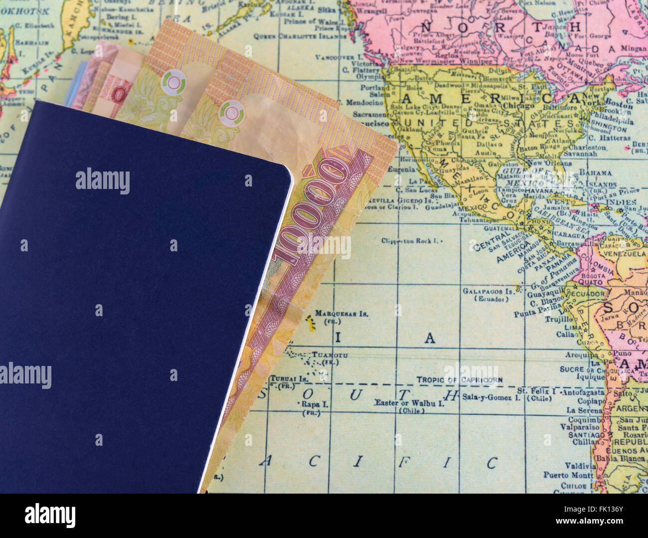 Passaporto con denaro sulla mappa del mondo sullo sfondo Foto Stock